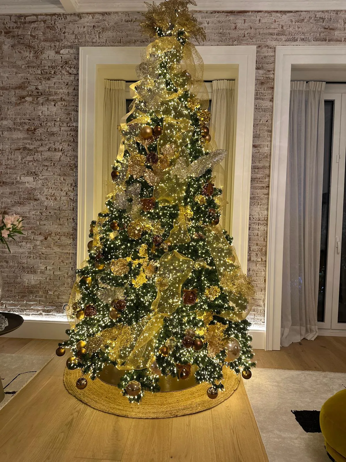 Árbol de Navidad decorado en dorado con luces cálidas por capas