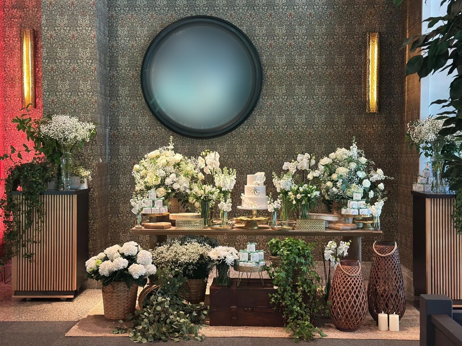 Mesa dulce de boda en tonos blancos y verdes, con tarta de tres pisos y composiciones florales